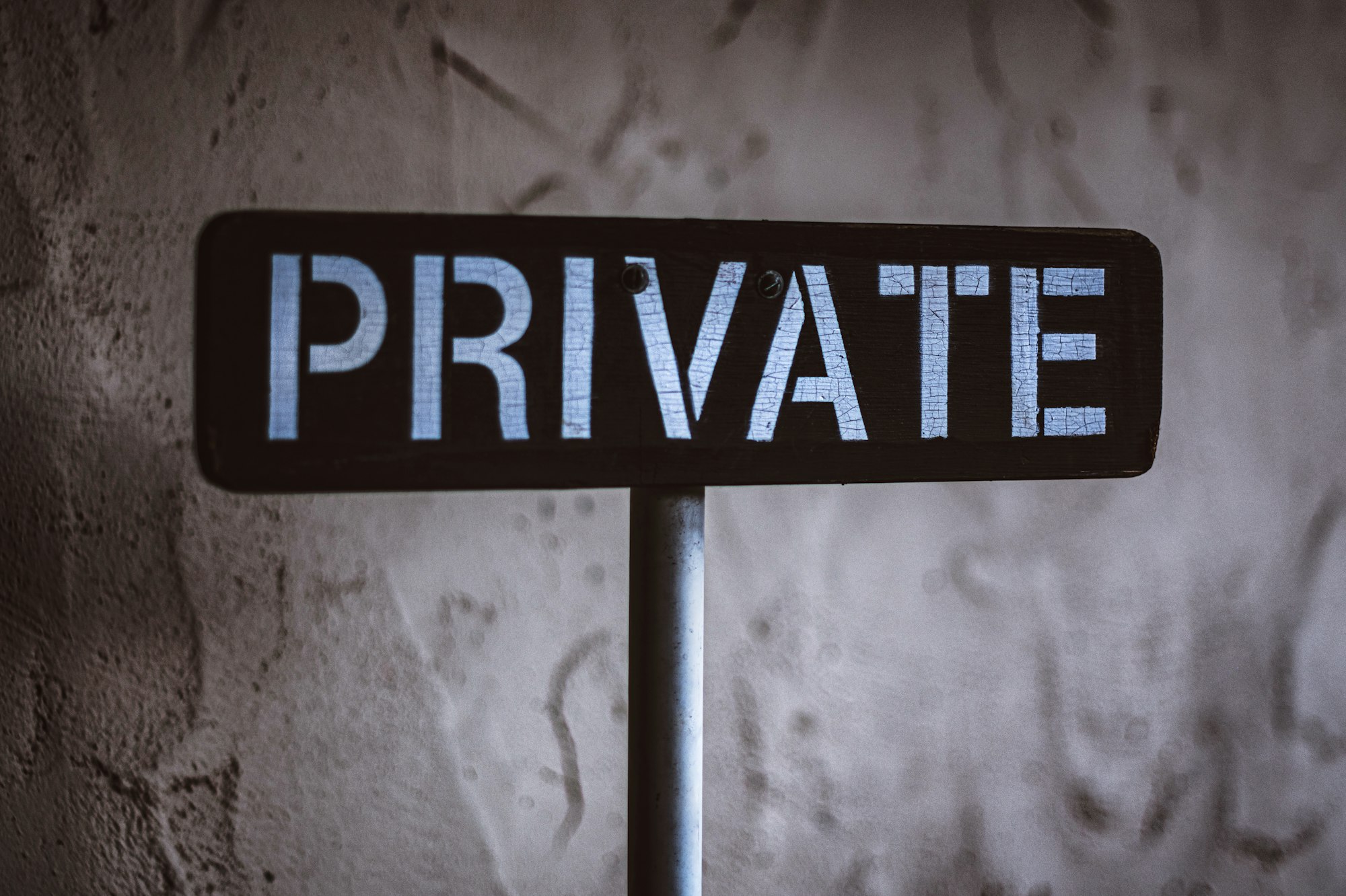 A sign reading Private on a weathered wall